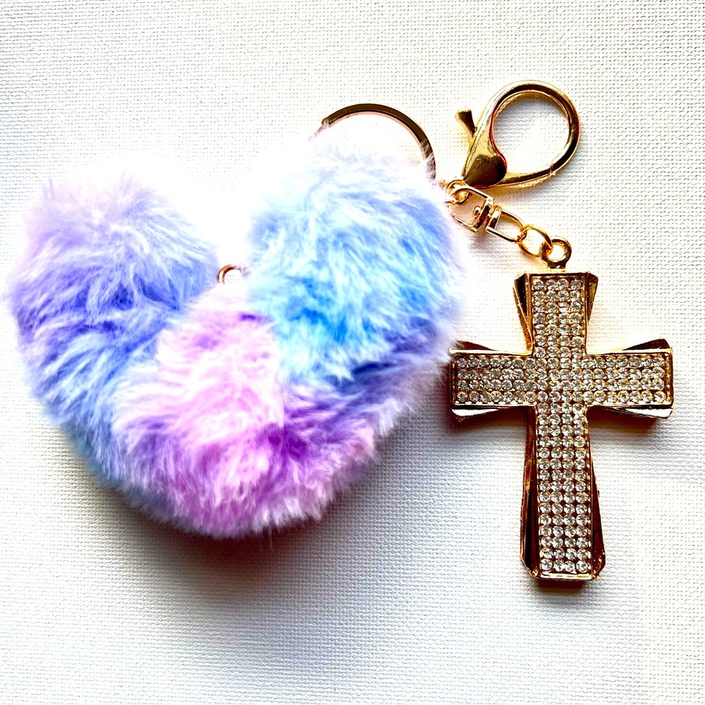 Llavero (Keychain) con pompón en forma de corazón y crucifijo.